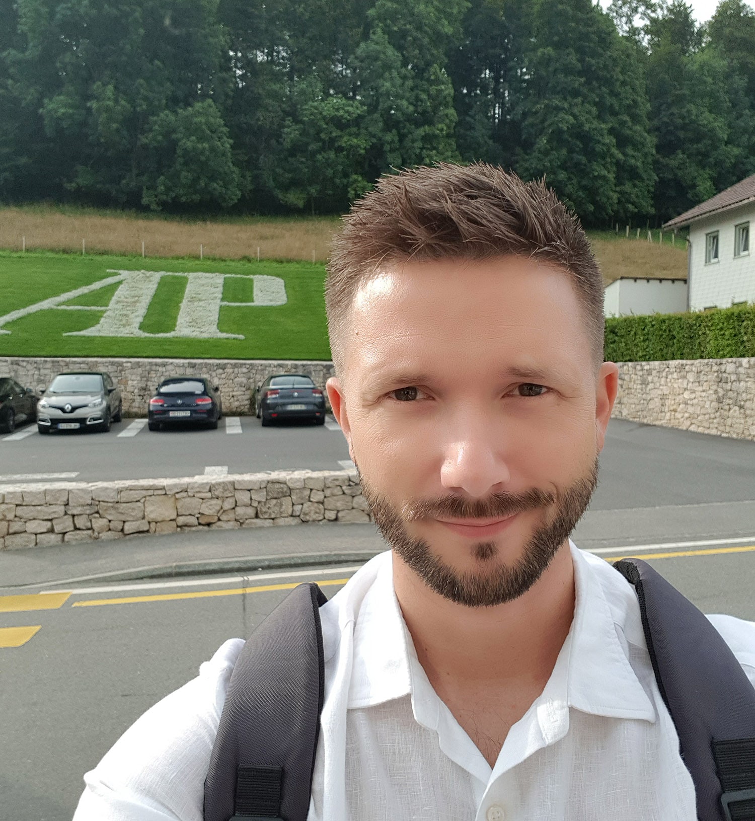 Man outside Audemars Piguet headquarters. AP logo on the grass.